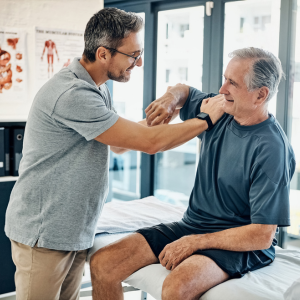 Patient receiving musculoskeletal pain treatment from a physiotherapist in a clinic setting