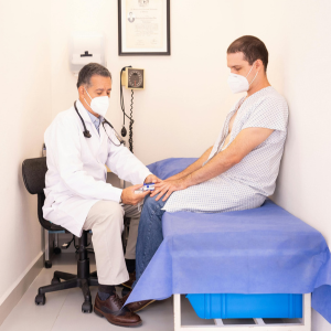 Middle-aged man undergoing preventive health screening with doctor at Seva Clinic